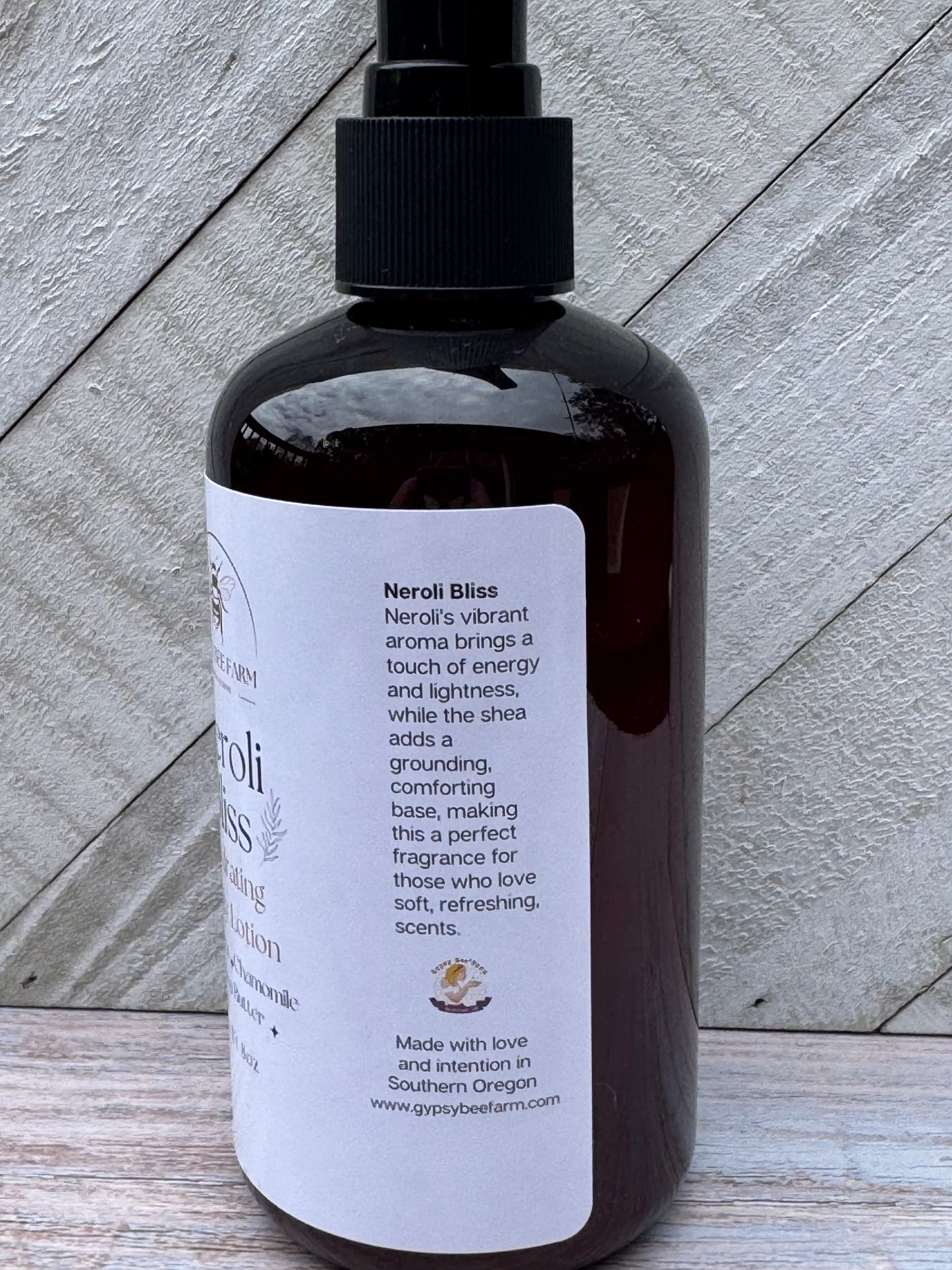 Bottle of Neroli Bliss Lotion on a wooden board.