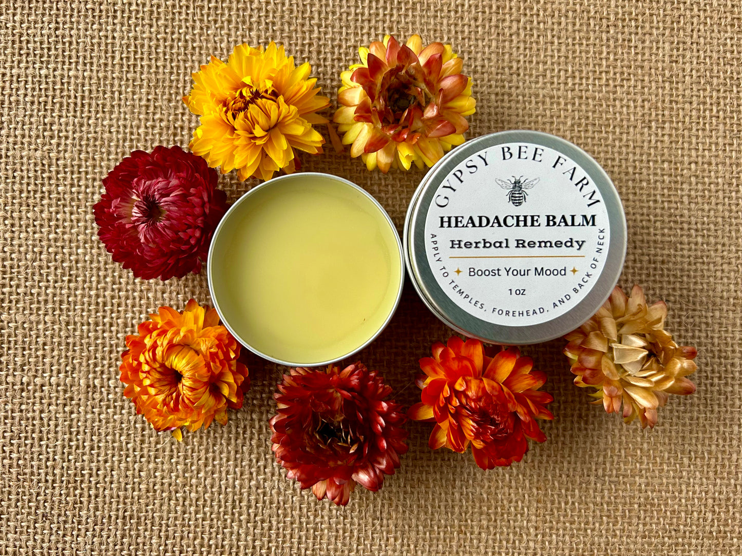 Gypsy Bee Farm Headache Balm with flowers on a textured surface