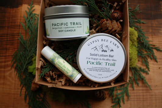 Gypsy Bee Farm and Pacific Trail skincare products in a box on a wooden surface.