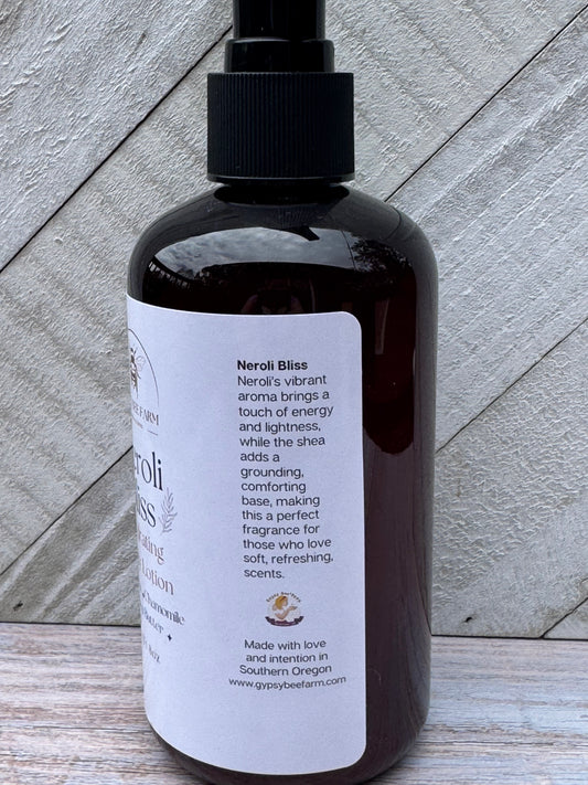 Bottle of Neroli Bliss Lotion on a wooden board.