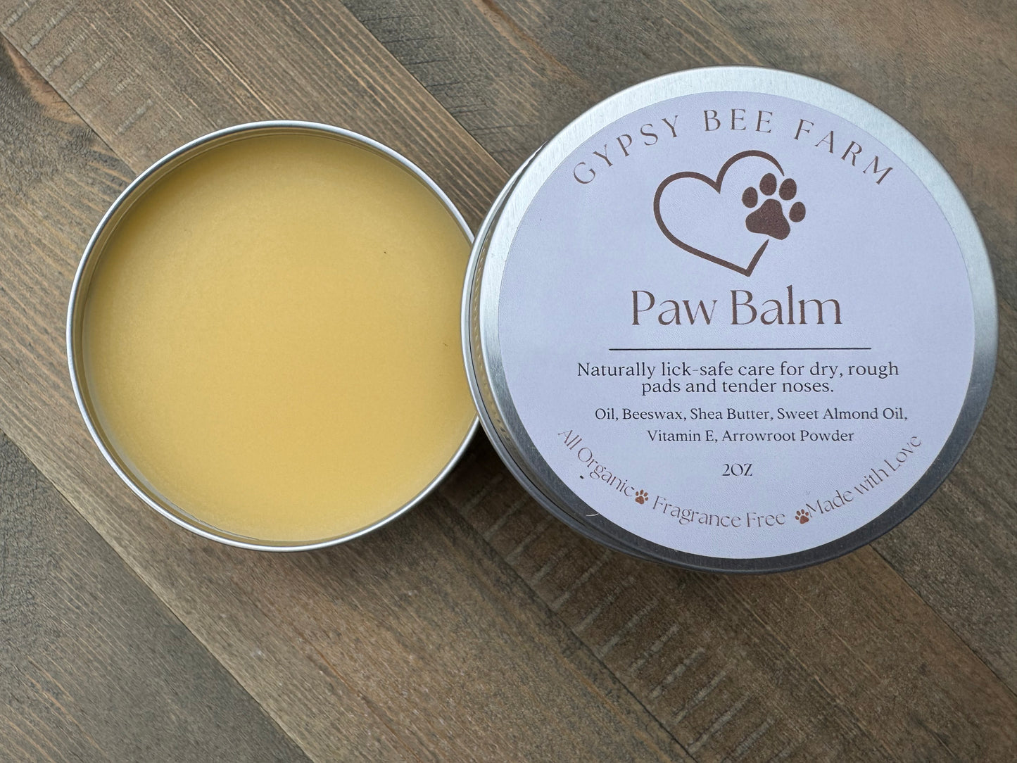 Gypsy Bee Farm Paw Balm in a metal tin on a wooden surface