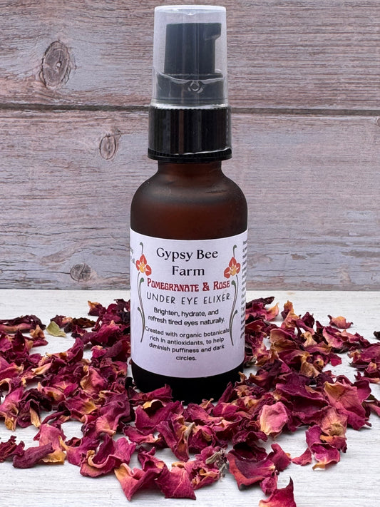 Bottle of Gypsy Bee Farm product surrounded by dried flowers on a wooden surface