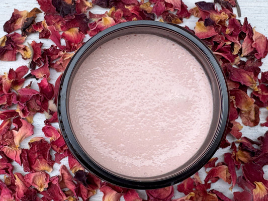 Cosmetic jar with pink cream on a bed of dried red flowers