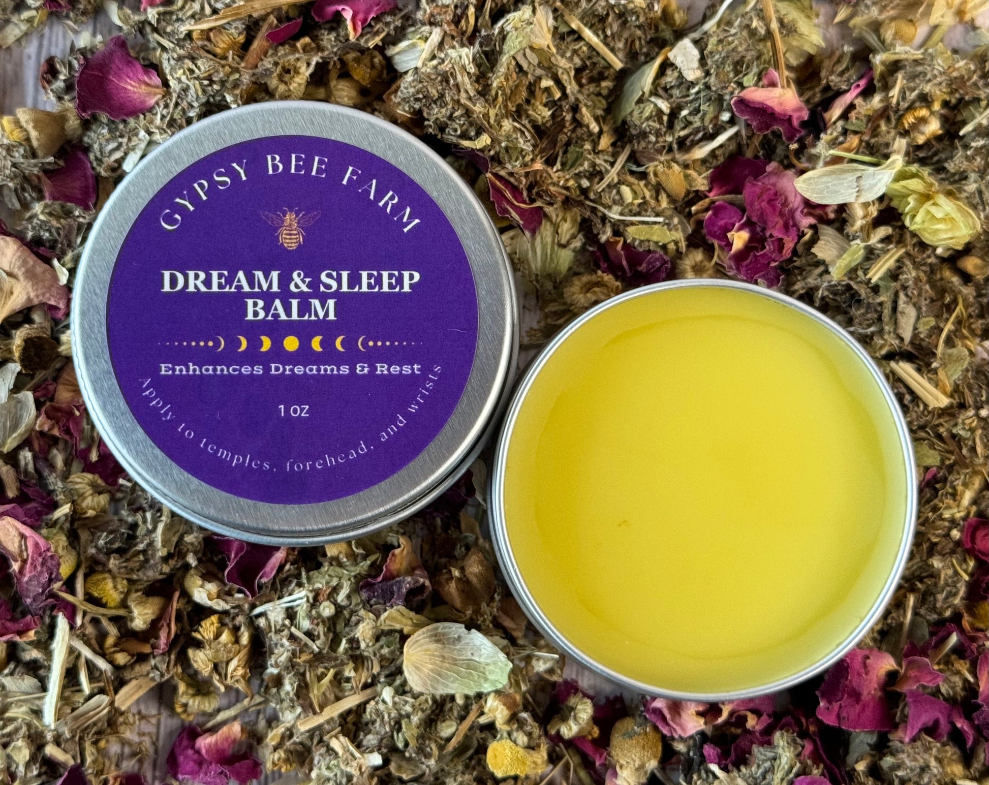 Gypsy Bee Farm Dream & Sleep Balm in a tin surrounded by dried herbs and flowers.