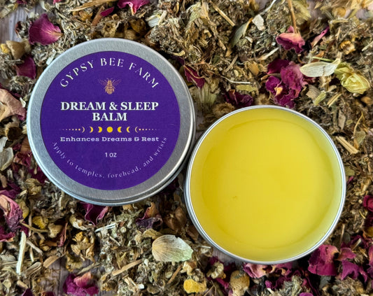 Gypsy Bee Farm Dream & Sleep Balm in a tin surrounded by dried herbs and flowers.