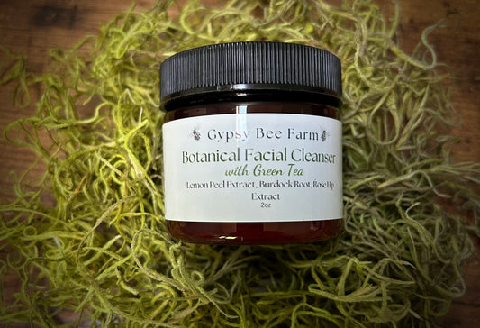 Jar of Gypsy Bee Farm Botanical Facial Cleanser with Green Tea on a textured surface