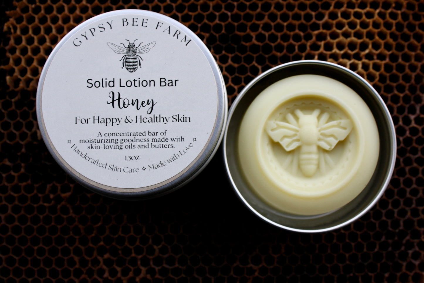 Gypsy Bee Farm solid lotion bar in a metal container on a honeycomb background