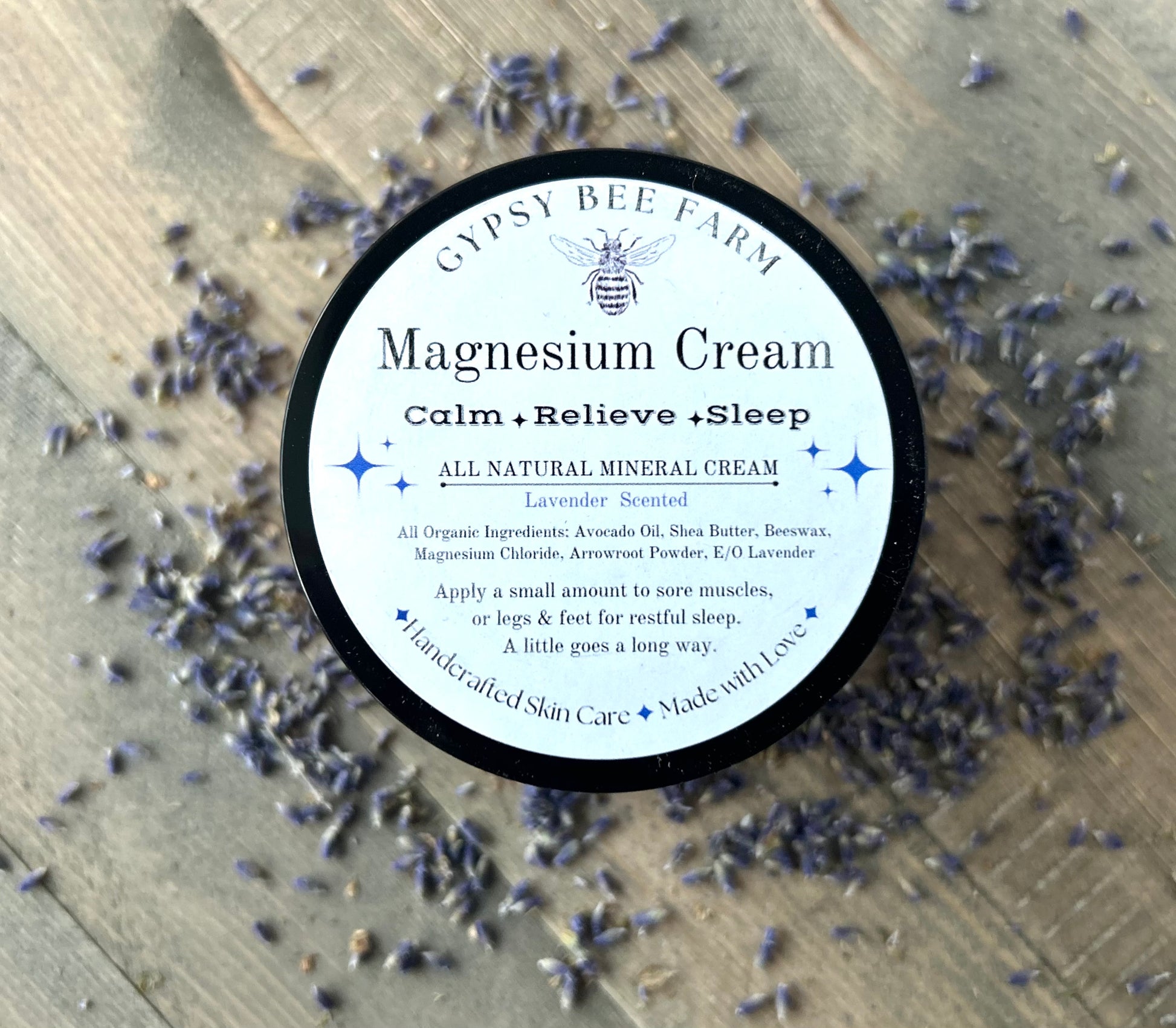 Gypsy Bee Farm magnesium cream container surrounded by lavender flowers on a wooden surface
