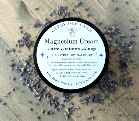 Gypsy Bee Farm magnesium cream container surrounded by lavender flowers on a wooden surface