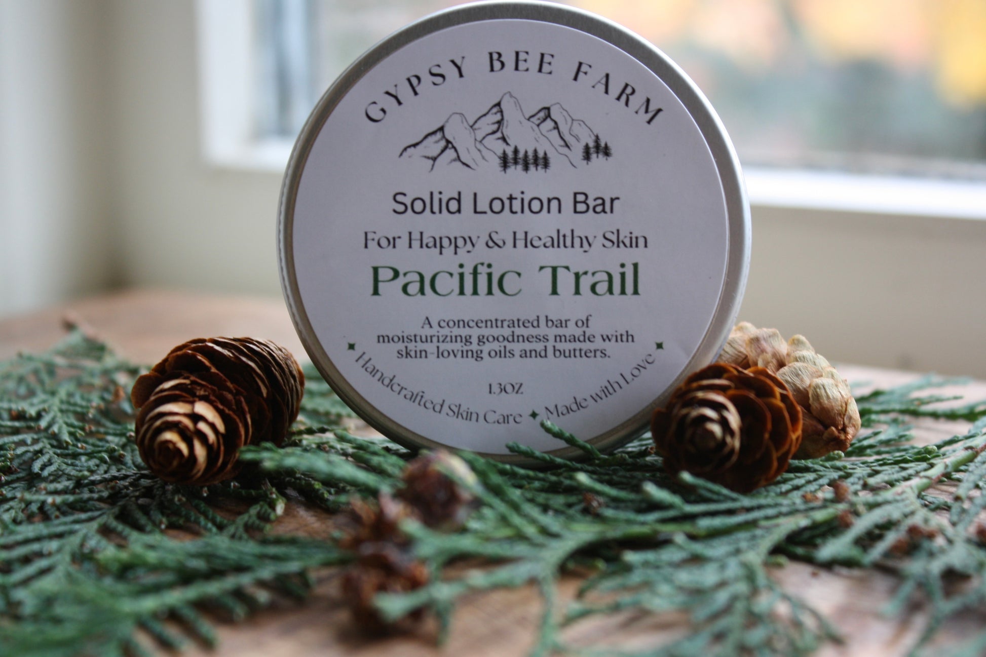 Gypsy Bee Farm solid lotion bar on a decorative surface with pine cones and greenery.